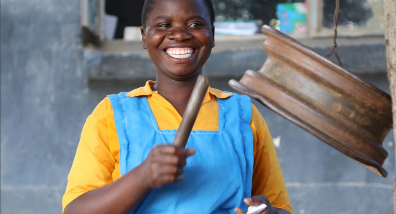 Girl smiling and playing an instrument made of metal