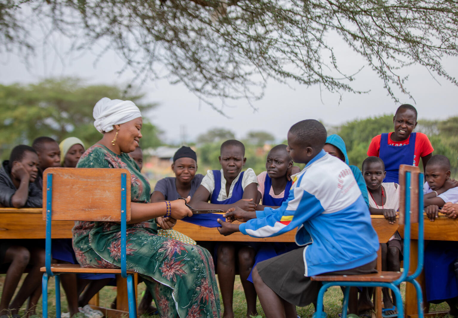 The Senior Woman Teacher at Katikit Primary School, Lucy Nyambura shows members of the Girls O School