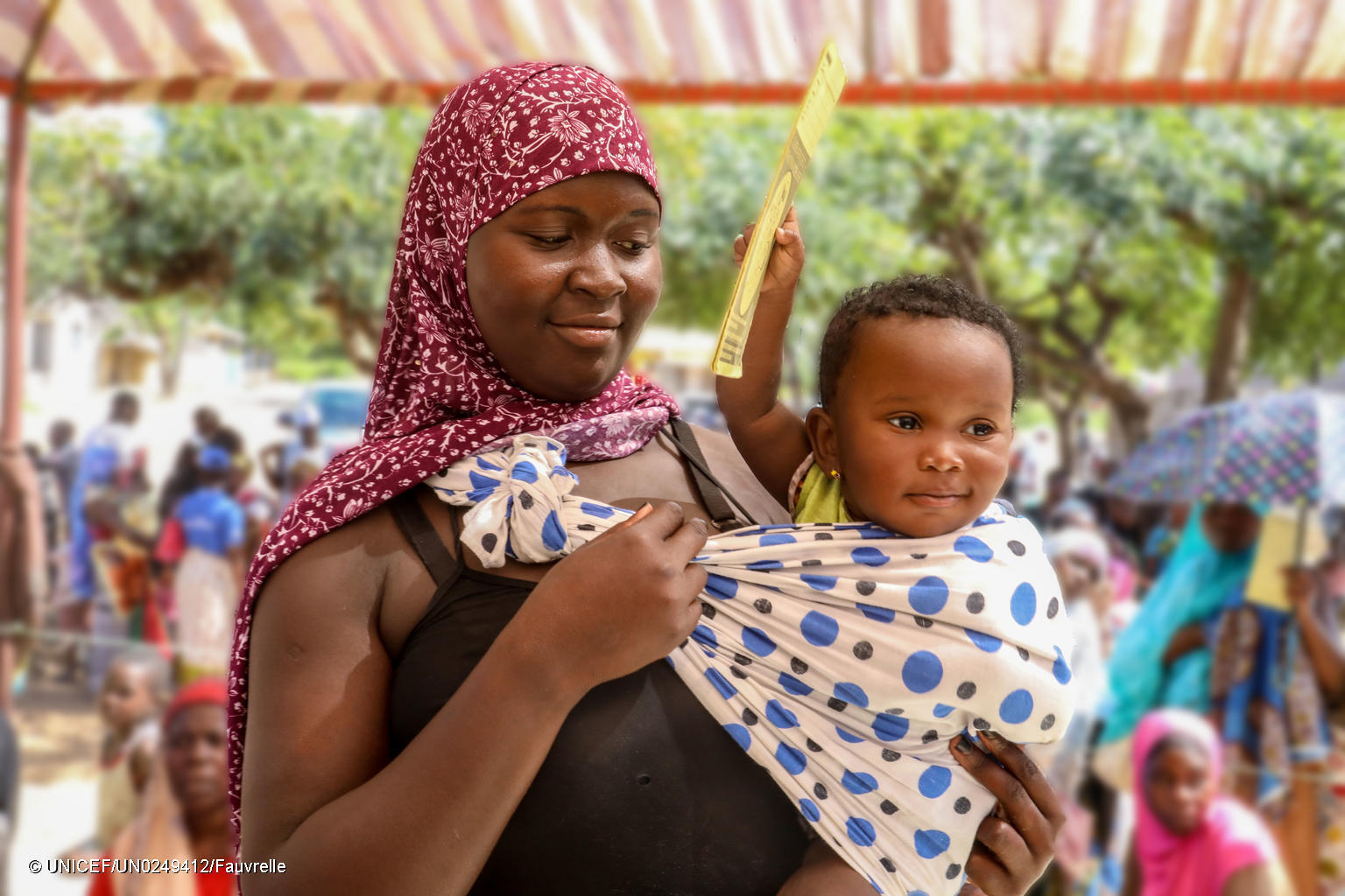 Image: Mother and her child attending a UNICEF health fair in Mozambique.