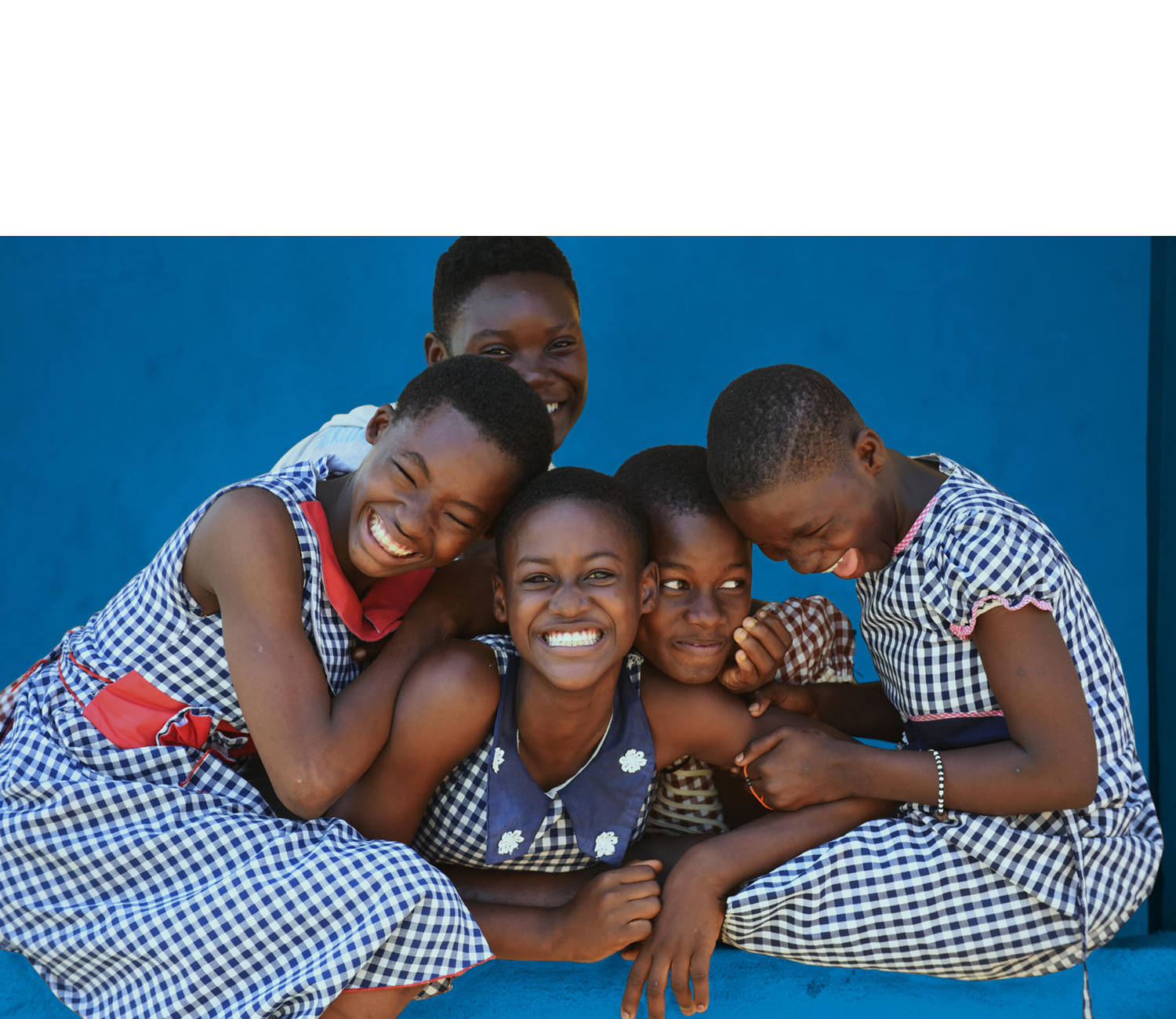 five young girls leaning on each other, laughing and smiling