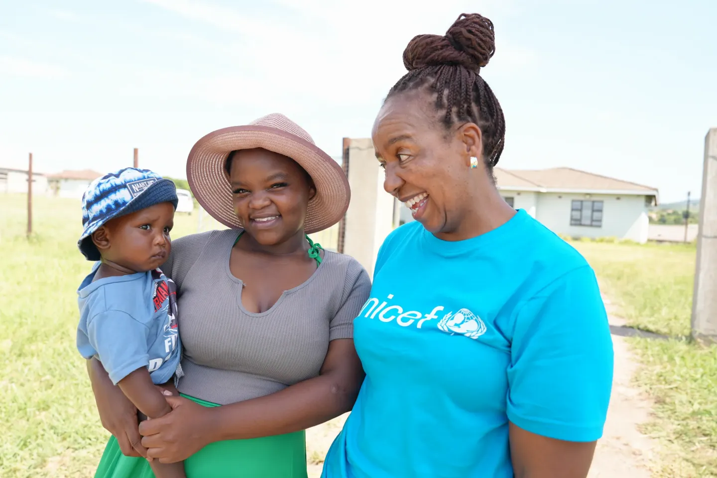 A young mother and her son stand with Boitumelo Morakile, UNICEF South Africa, HIV/AIDS Officer